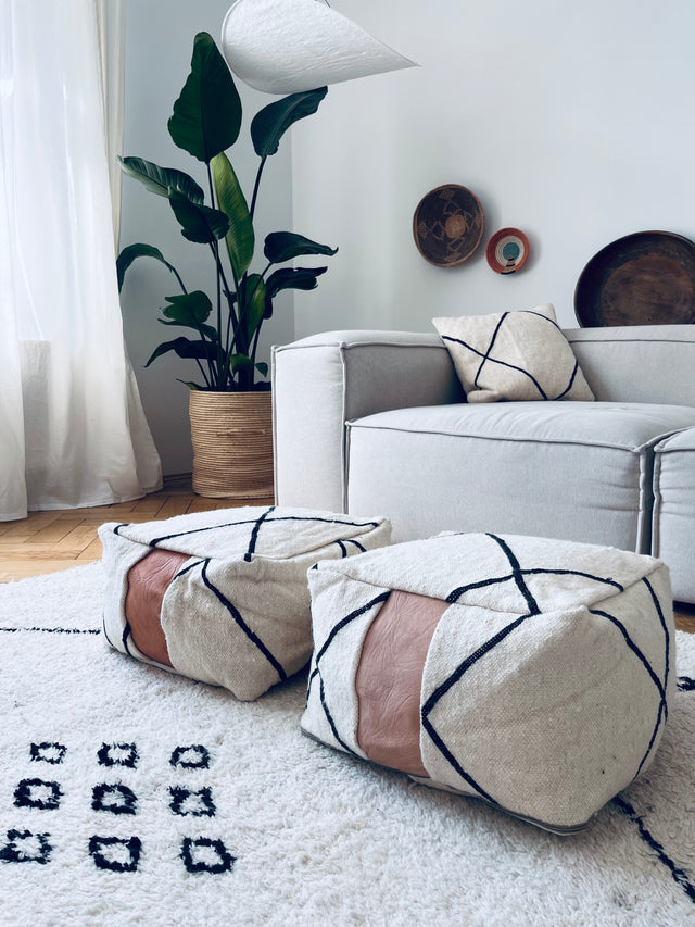 2 Bodenkissen auf hellem Beni Ourain vor Sofa