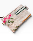 Die LEY! Tasche - Colorful Line - 15 x 20 ist eine kleine, gewebte Clutch mit weißem Hintergrund, rosa und grünem Blumenmuster, grünen und orangefarbenen Linien, Reißverschluss und einem seitlichen Stoffanhänger.