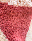Nahaufnahme des Berber-Teppichs „THE DANISH GIRL INTERIOR“ – Tazita, 0,60 x 1,10 m, in Rosa, Weiß und Creme mit Fransen.