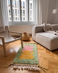 Helles Wohnzimmer mit einem Berber-Teppich von THE DANISH GIRL INTERIOR – Bariq, einem beigen Sessel, einem Sofa, einem Korb und weißen Vorhängen.