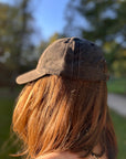 Eine Frau mit braunen Haaren trägt die LEY! „Habibi“-Kappe in Rosa und steht im Freien mit dem Rücken zur Kamera.