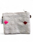 Die LEY! Tasche - Colorful Line - 15x20cm ist eine kleine, strukturierte weiße Wolltasche mit Reißverschluss, mit rosa und roten Rauten auf der Vorderseite, Details von Handarbeit Marrakesch, einem linken weißen Anhänger und einem Metallclip am Reißverschluss.