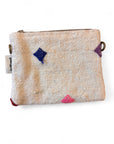 Die LEY! Tasche - Colorful Line (15x20cm) ist eine kleine, rechteckige weiße Schurwolltasche mit strukturiertem Stoff, bunten Rautenmustern in Blau, Pink, Lila und Rot, einem Reißverschluss, Handarbeit Marrakesch-Details, Seitenanhänger und Metallschlaufen.