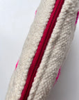 Nahaufnahme der LEY! Tasche - Mona Pink - 20x30cm: handgefertigte cremefarbene Schurwolle, ein vertikaler Reißverschluss in leuchtendem Pink, sichtbare Nähte und pinke Flecken verleihen dieser praktischen Kosmetiktasche Charakter.