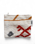 Die LEY! Tasche - Colorful Line (15x20cm) ist eine kleine, strukturierte weiße Kosmetiktasche mit geometrischen Mustern in Rot, Schwarz und Orange, Reißverschluss und einem weißen "LEY!"-Anhänger. Handgefertigt in Marrakesch und abgebildet auf einem einfarbig weißen Hintergrund.