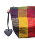 Nachtblauer Taschenanhänger – „Love Loop“ von LEY! mit einem Herzanhänger aus Kunstleder an einem bunten, karierten Beutel.