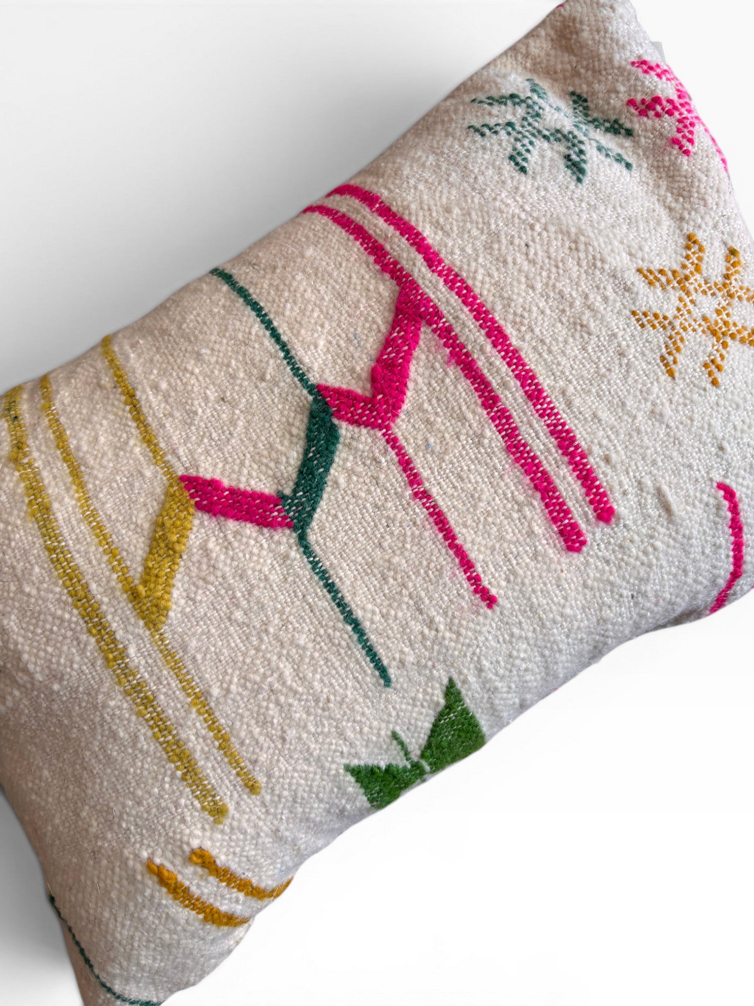 Das LEY! Kissen - Colorful Line - 40 x 60 von LEY! ist ein rechteckiges, cremefarbenes Kissen mit strukturiertem Stoff und lebendigen, abstrakten Mustern in Rosa, Gelb, Grün und Blau, die mit Linien, Formen und sternförmigen Details einen lebendigen Akzent setzen.