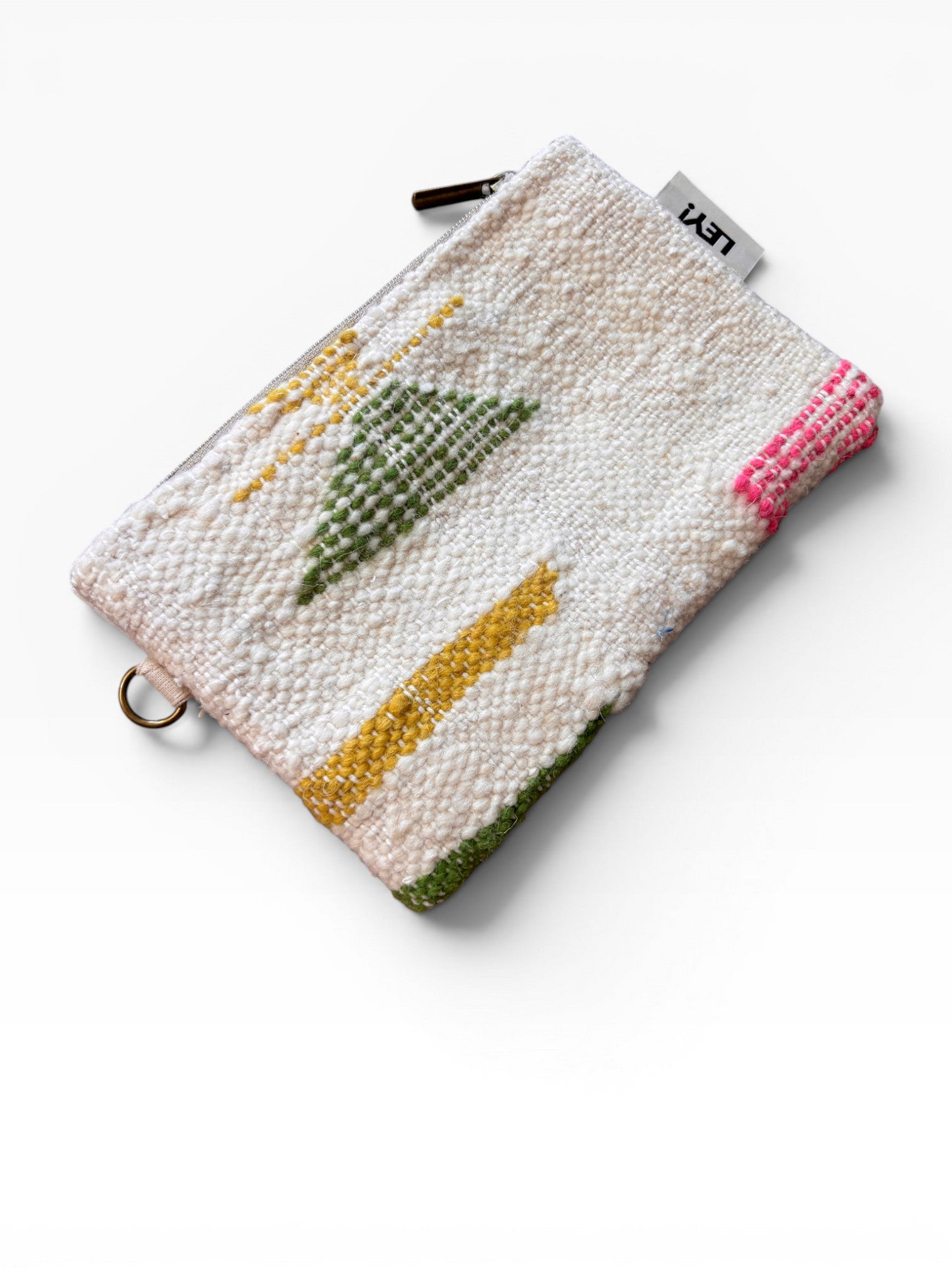Die LEY! Tasche - Colorful Line - 15 x 20 ist eine kleine, strukturierte Stofftasche mit Reißverschluss, aufgestickten geometrischen Mustern in Gelb, Grün und Rosa und einem weißen "LUSH"-Anhänger, der herausragt. Ausgestellt auf weißem Hintergrund.