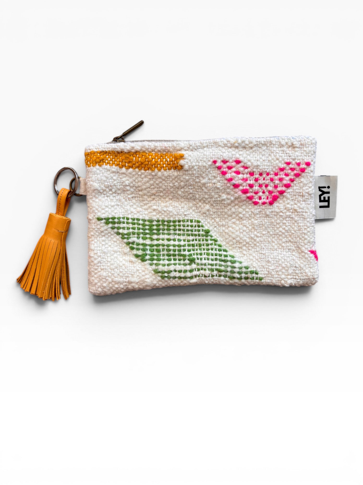 Die LEY! Tasche - Colorful Line - 15 x 20 ist eine kleine weiße Clutch mit Reißverschluss, gelber Quaste, geometrischen Mustern in Rosa, Grün und Gelb, aus strukturiertem Schurwolle-Stoff und mit einem Anhänger auf der rechten Seite.