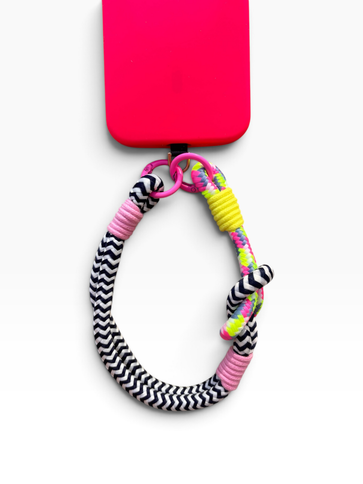 Ein Handy mit einer rosa Hülle, einer LEY! Schwarz-Weiß „LUJA“-Handykette sowie einem farbenfrohen Handyband.