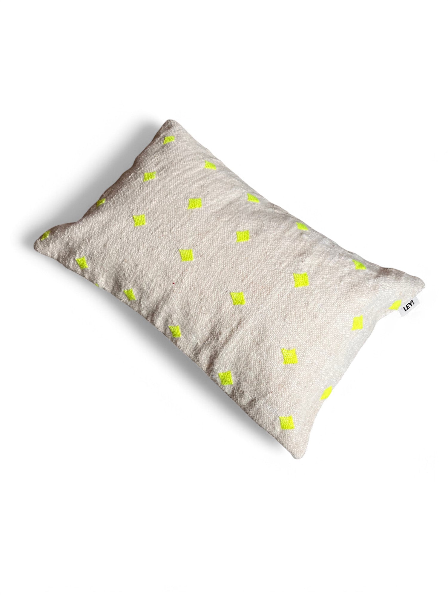 Das Kissen - Mona Neongelb - 40 x 60 von LEY! ist ein rechteckiges, beigefarbenes Kissen mit strukturiertem Stoff, leuchtend gelben Rautenmustern und einem seitlichen Stoffanhänger. Es wird in Marrakesch handgefertigt.