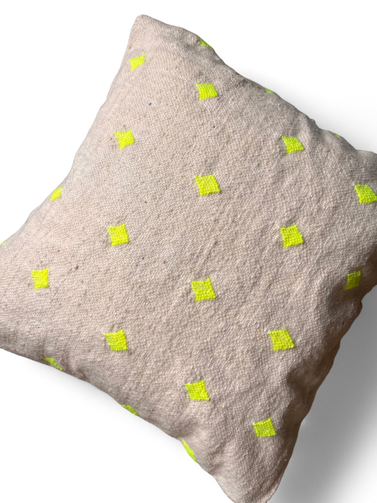 Das Kissen - Mona Neongelb - 50 x 50 von LEY! ist ein quadratisches, beigefarbenes Kissen mit strukturiertem Stoff und kleinen gelben Rautenmustern, das in Marrakesch handgefertigt wurde und auf weißem Hintergrund zu sehen ist.