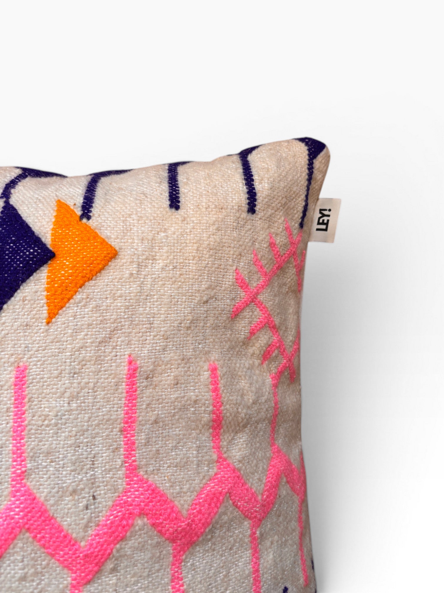 Das LEY! Kissen - Colorful Line, 60 x 60 cm, zeigt rosa Zickzack, orange und marineblaue geometrische Muster.
