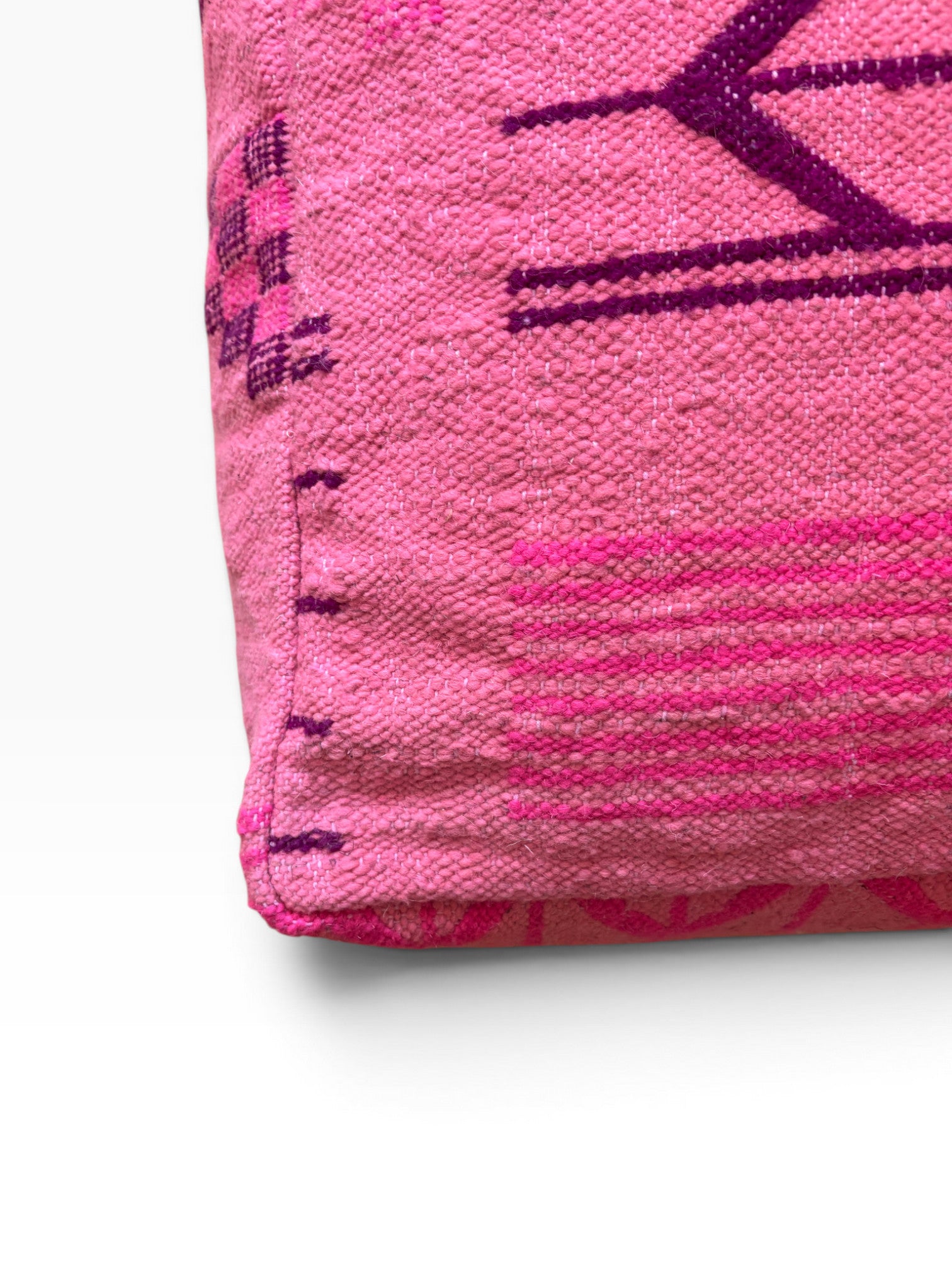 Nahaufnahme des LEY! Bodenkissen - Colorful Line - Pink Edition mit lila geometrischen Mustern auf weißem Hintergrund.