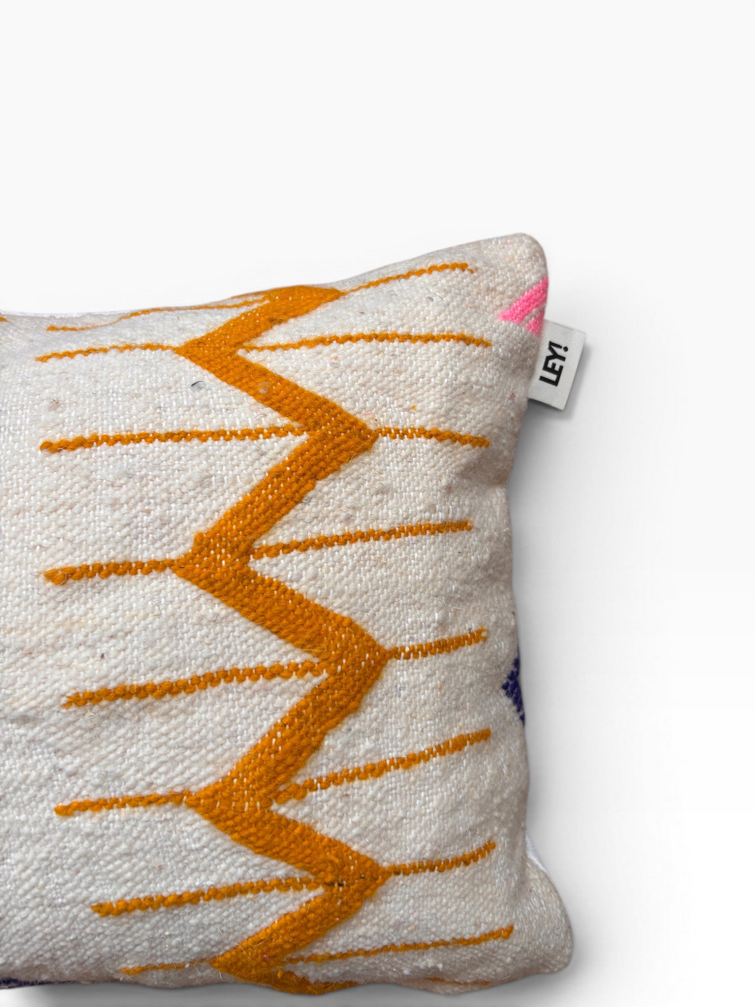 LEY! Kissen - Colorful Line 40x60 aus Schurwolle mit orange-pinkem Muster, teils auf neutralem Hintergrund gezeigt.