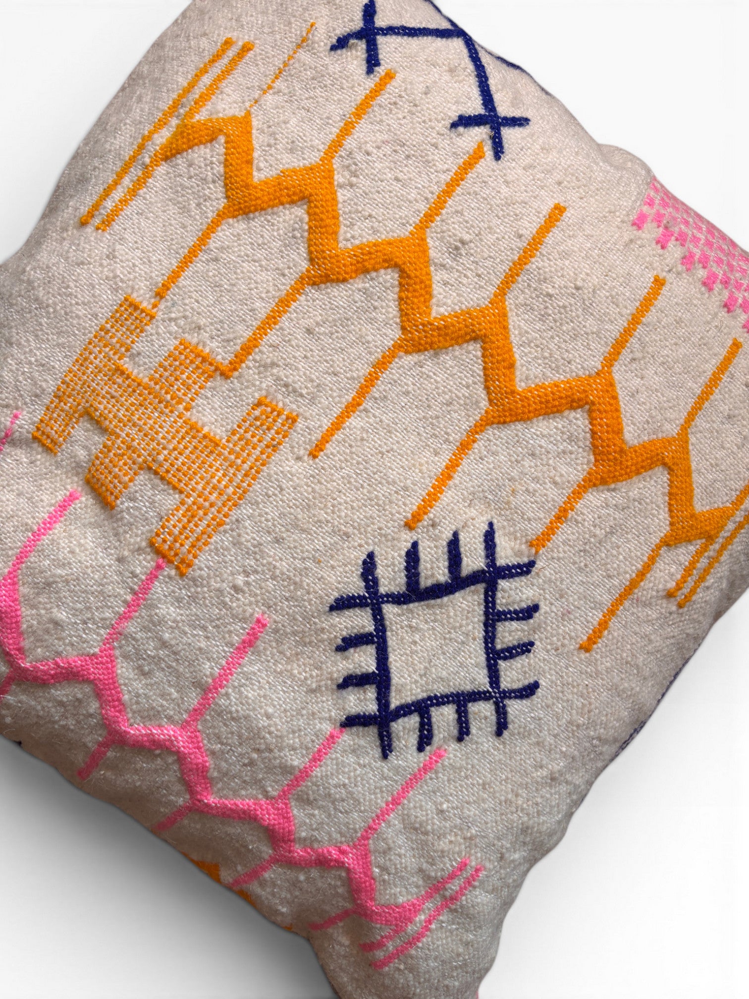Das LEY! Kissen - Colorful Line - 60 x 60 ist ein quadratisches Kissen mit cremefarbenem Schurwolle-Bezug und geometrischen Ziernähten.