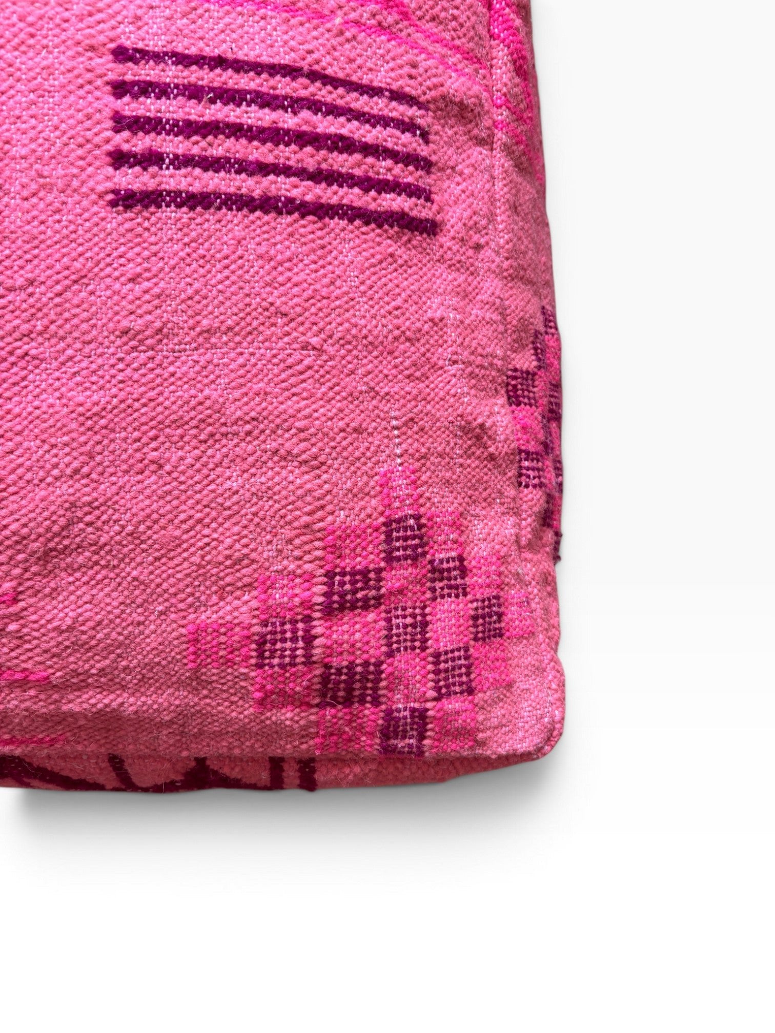 Eine Nahaufnahme des LEY! Bodenkissen - Colorful Line - Pink Edition, gewebt mit dunkleren rosa Streifenmustern.