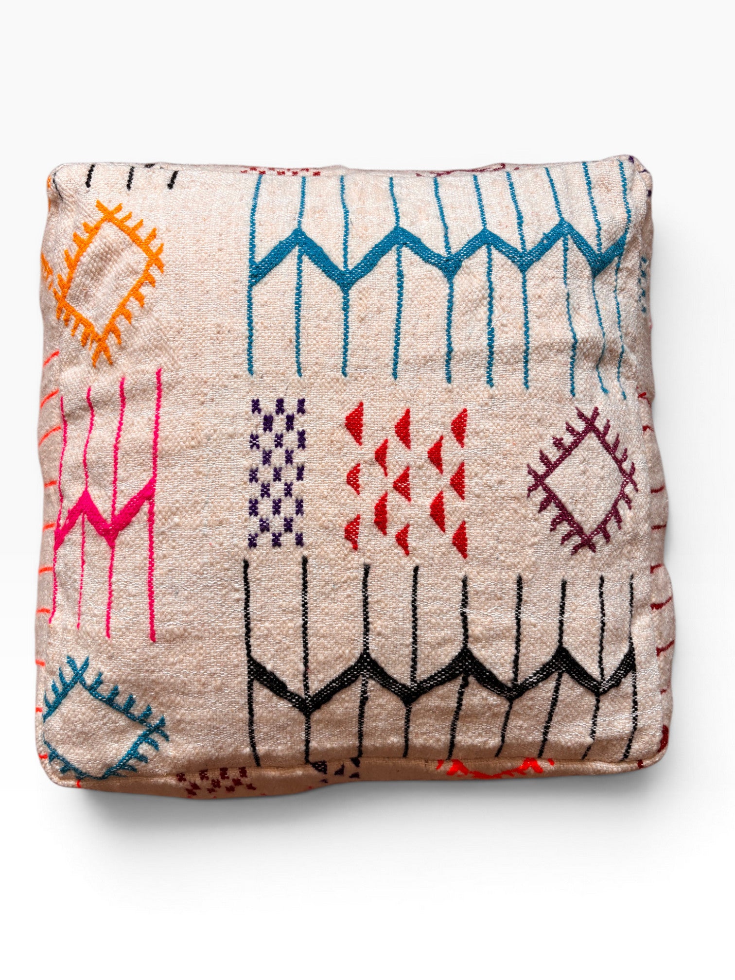 Ein gefaltetes LEY! Bodenkissen - Colorful Line - Lana in Beige mit lebendiger geometrischer Stickerei in Blau, Pink, Orange und Rot.