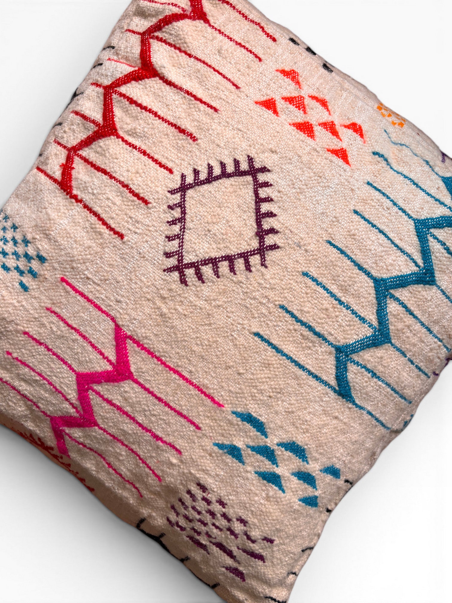 LEY! Bodenkissen - Colorful Line - Laura: cremefarbenes Kissen mit roten, blauen und orangefarbenen geometrischen und Zickzack-Mustern.