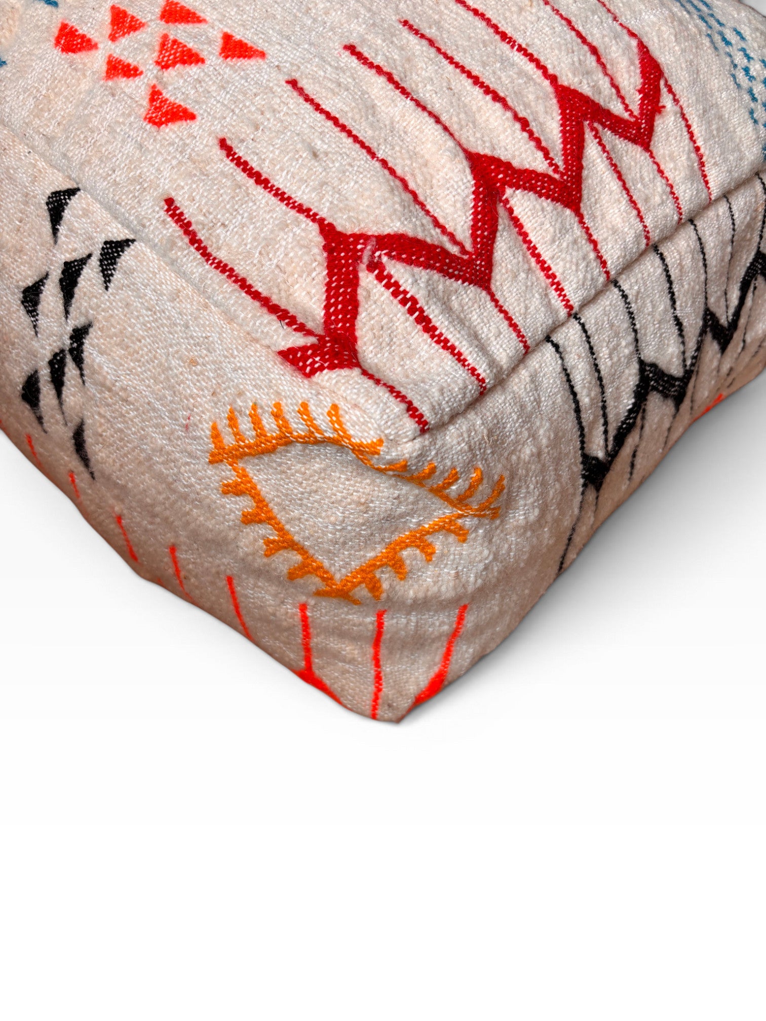 Nahaufnahme des LEY! Bodenkissen - Colorful Line - Laura mit geometrischer Stickerei in Rot, Schwarz und Orange.
