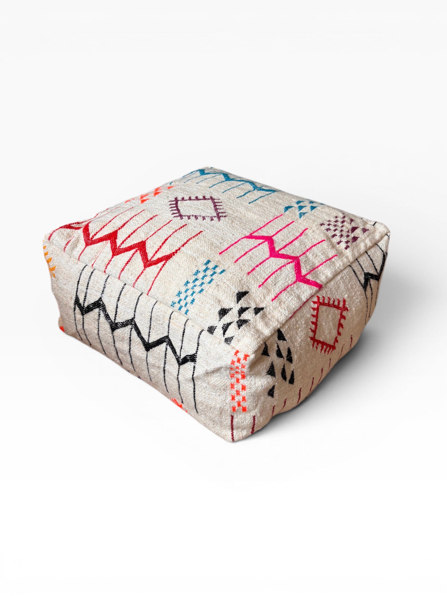 LEY! Bodenkissen - Colorful Line - Laura: quadratischer Hocker mit beigem Sockel und geometrischen Mustern in Rot, Blau und Orange.