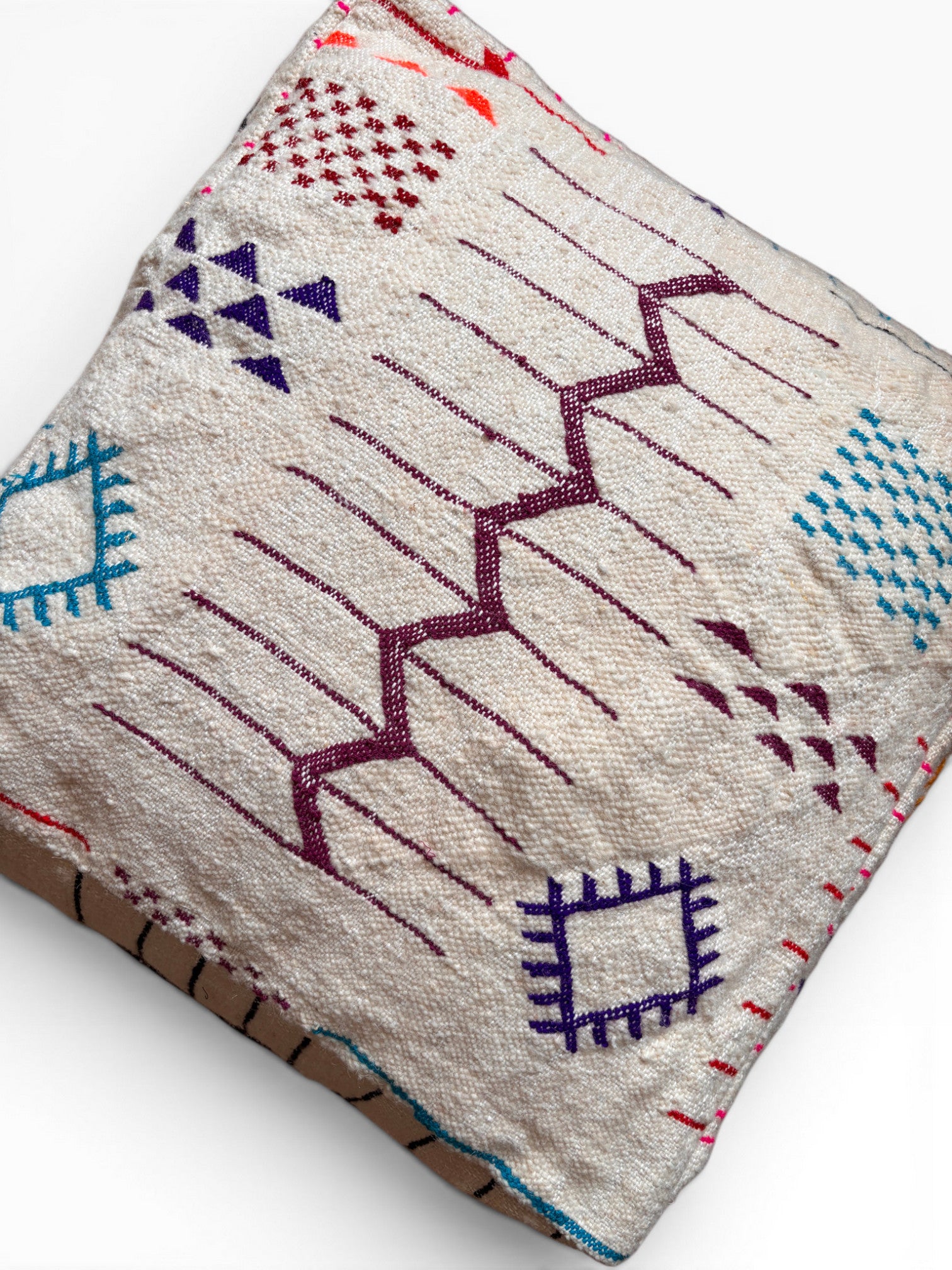 Bodenkissen - Colorful Line - Limana von LEY!: Ein quadratisches Kissen im Boho-Stil mit bunter geometrischer Stickerei auf Creme.