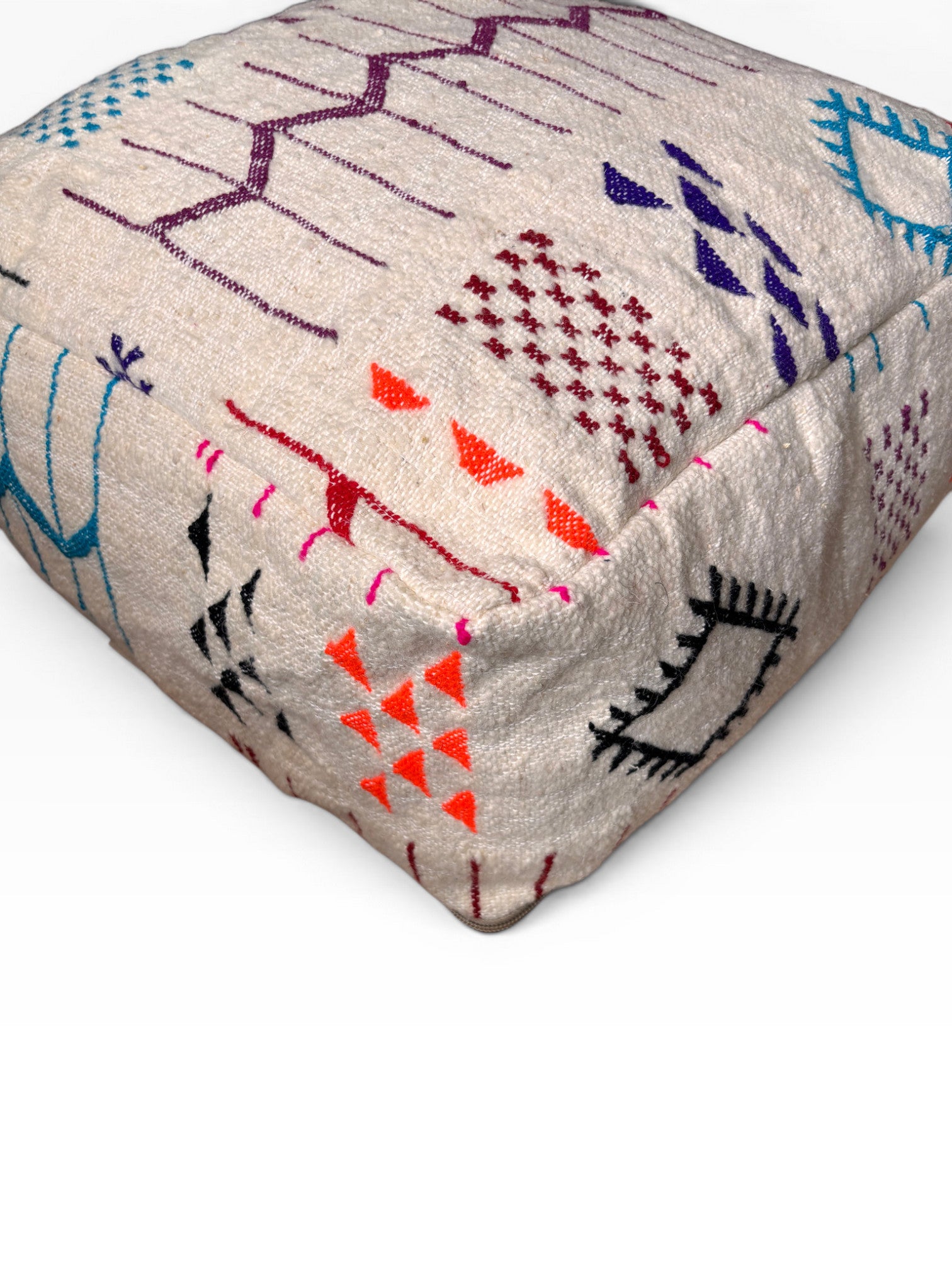 Das LEY! Bodenkissen - Colorful Line - Limana ist ein beiges Boho-Kissen mit roten, blauen, lila und schwarzen Stickereien.