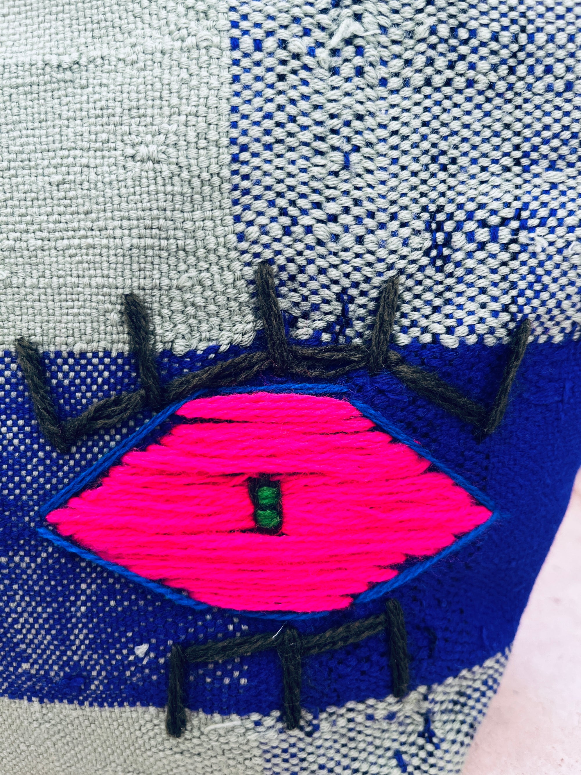 Die LEY! Tasche - Kosmetiktasche aus handgewebtem, blau-grau kariertem Stoff begeistert mit handgesticktem pinken Auge und dunklen Wimpern - ein einzigartiges marokkanisches Unikat für deinen Alltag.