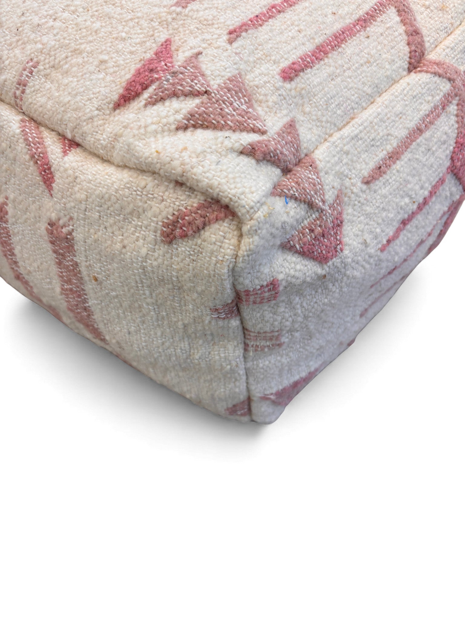 Eine Nahaufnahme des LEY! Kleines Bodenkissen - Classic Line - Mila Pale in Beige, das seinen strukturierten Stoff mit rosa Pfeilen und Linien zeigt. Detaillierte Nähte am Saum und an den Ecken unterstreichen seine handgefertigte Verarbeitung.