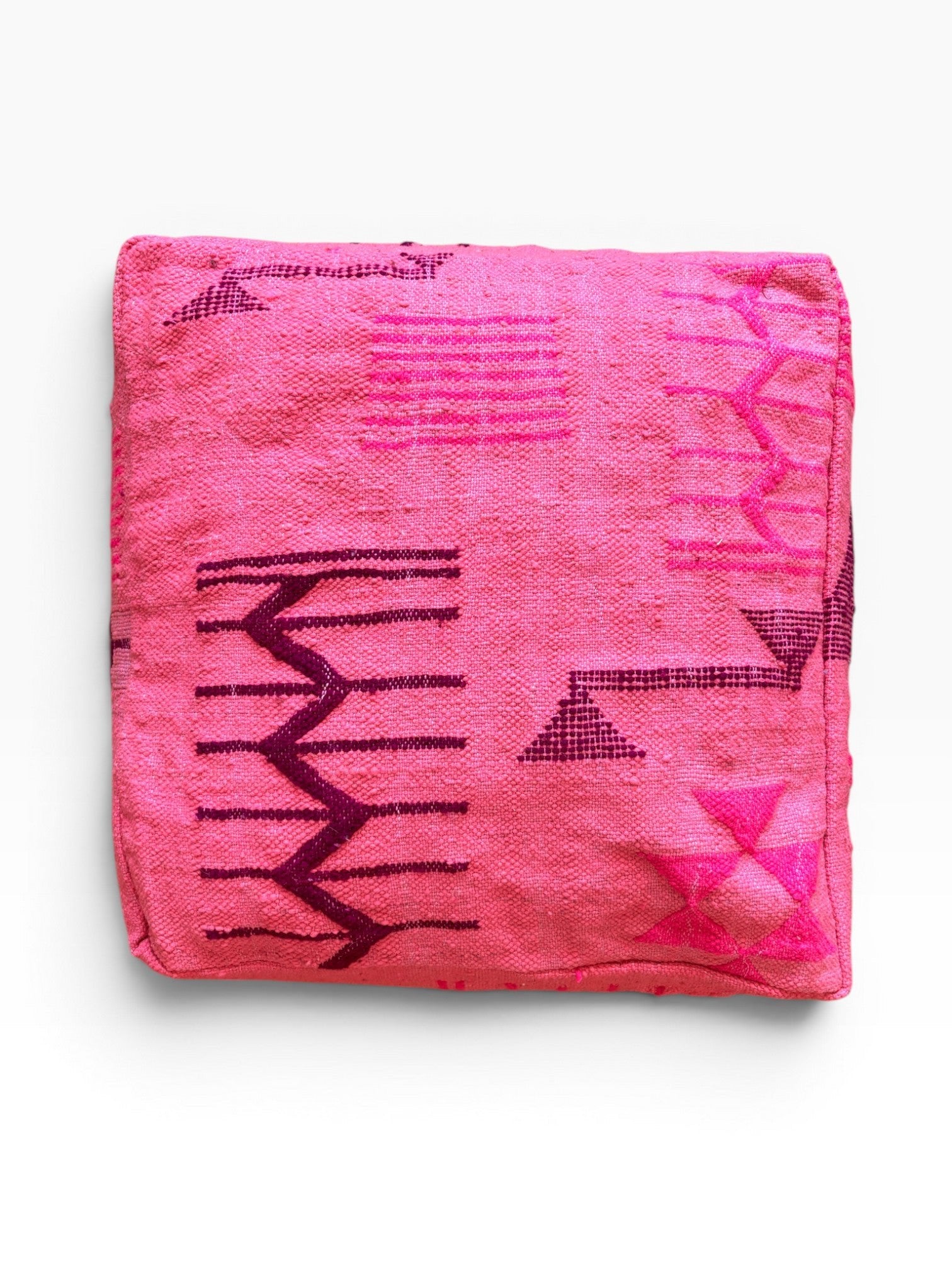 Das LEY! Bodenkissen - Colorful Line - Pink Edition zeigt auffällige violette geometrische und Zickzack-Muster auf rosa Wolle.