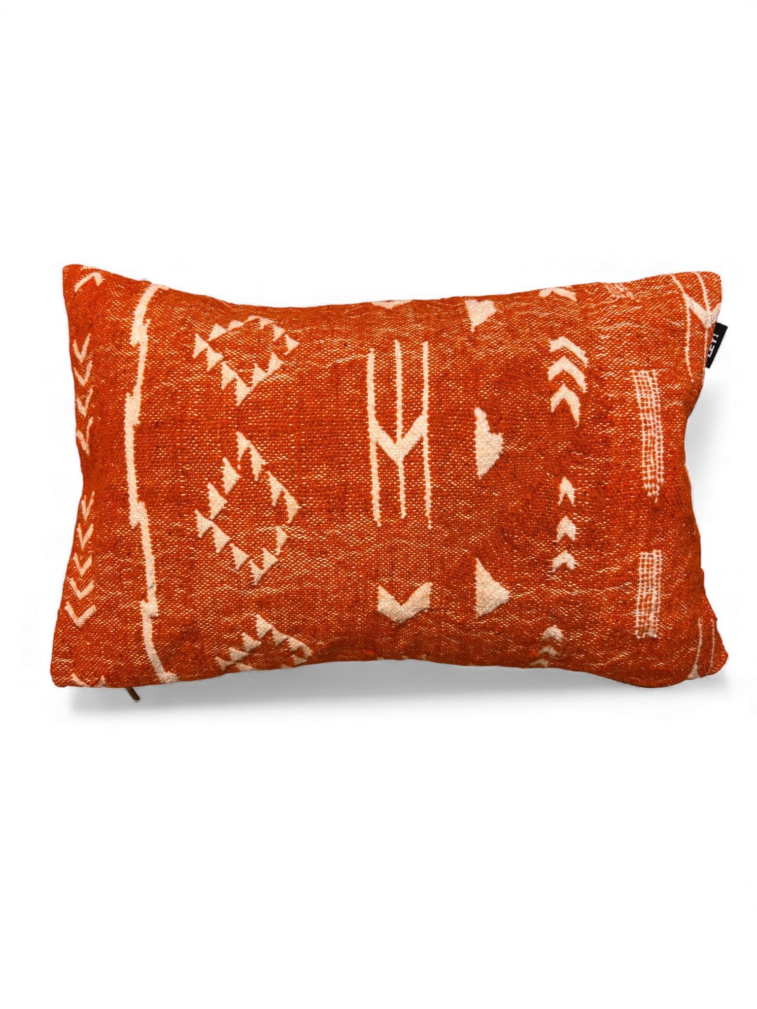 Das Kissen - Colorful Line - Mila Terracotta von LEY! (40 x 60 cm) zeigt weiße geometrische und tribal-inspirierte Muster auf orangefarbener Schurwolle, die in Marrakesch handgefertigt wurde und vor einem weißen Hintergrund steht.