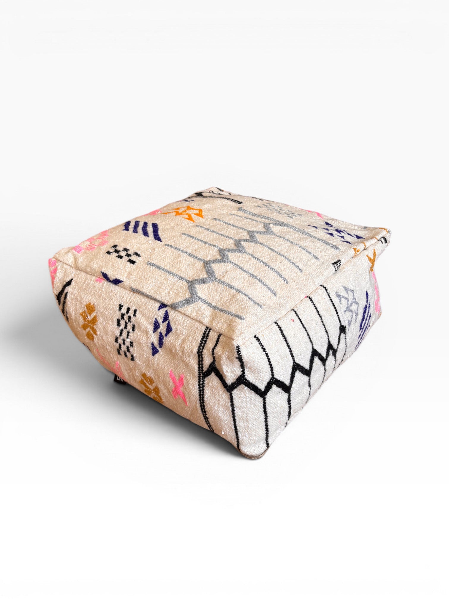 Das LEY! Bodenkissen - Colorful Line - Lima ist ein quadratischer beigefarbener Hocker mit geometrischen Boho-Mustern, der aus Wolle gefertigt ist.