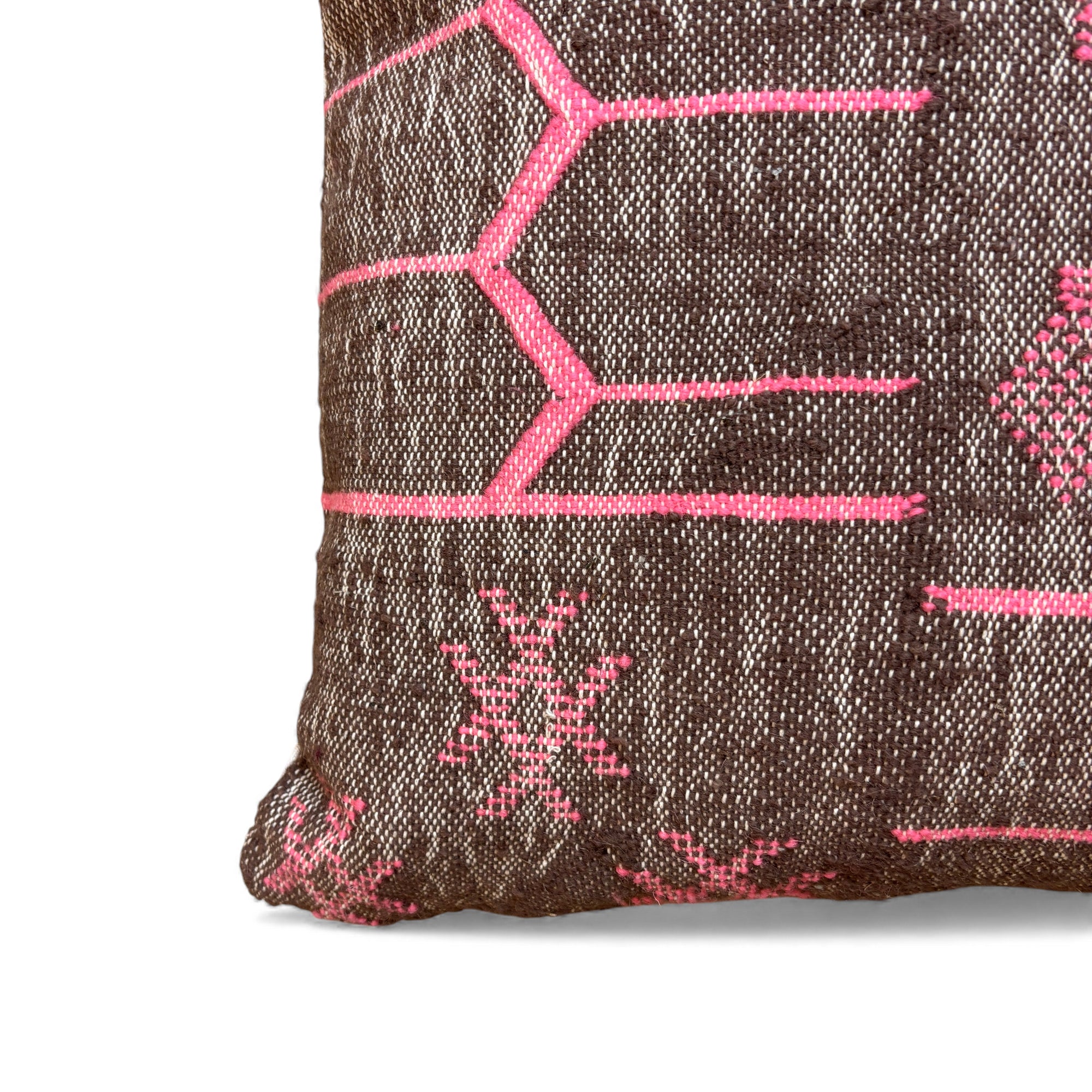 Eine Nahaufnahme des LEY! Kissen - Colorful Line - Fushia Edition 60x60 von LEY!, mit leuchtend rosa geometrischen Mustern auf brauner Schurwolle, handgefertigt in Marrakesch. Nur ein Teil dieses Kissens aus der Limited Edition ist sichtbar.