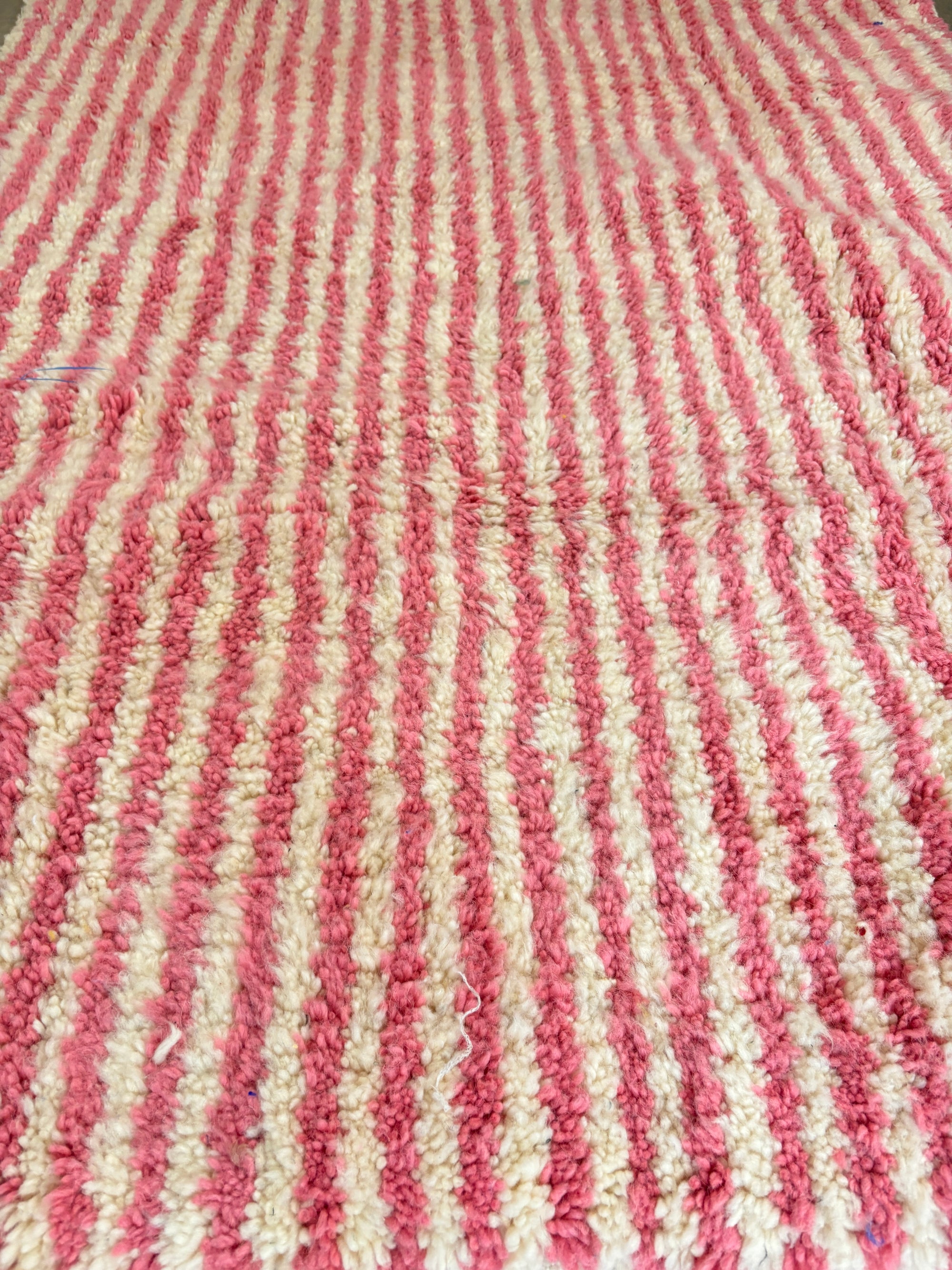 Nahaufnahme des LEY! Berberteppich - Pinq (1,20 x 2,00), mit einer strukturierten, handgewebten Optik in rosa und weißen Streifen; hergestellt aus reiner Schurwolle.