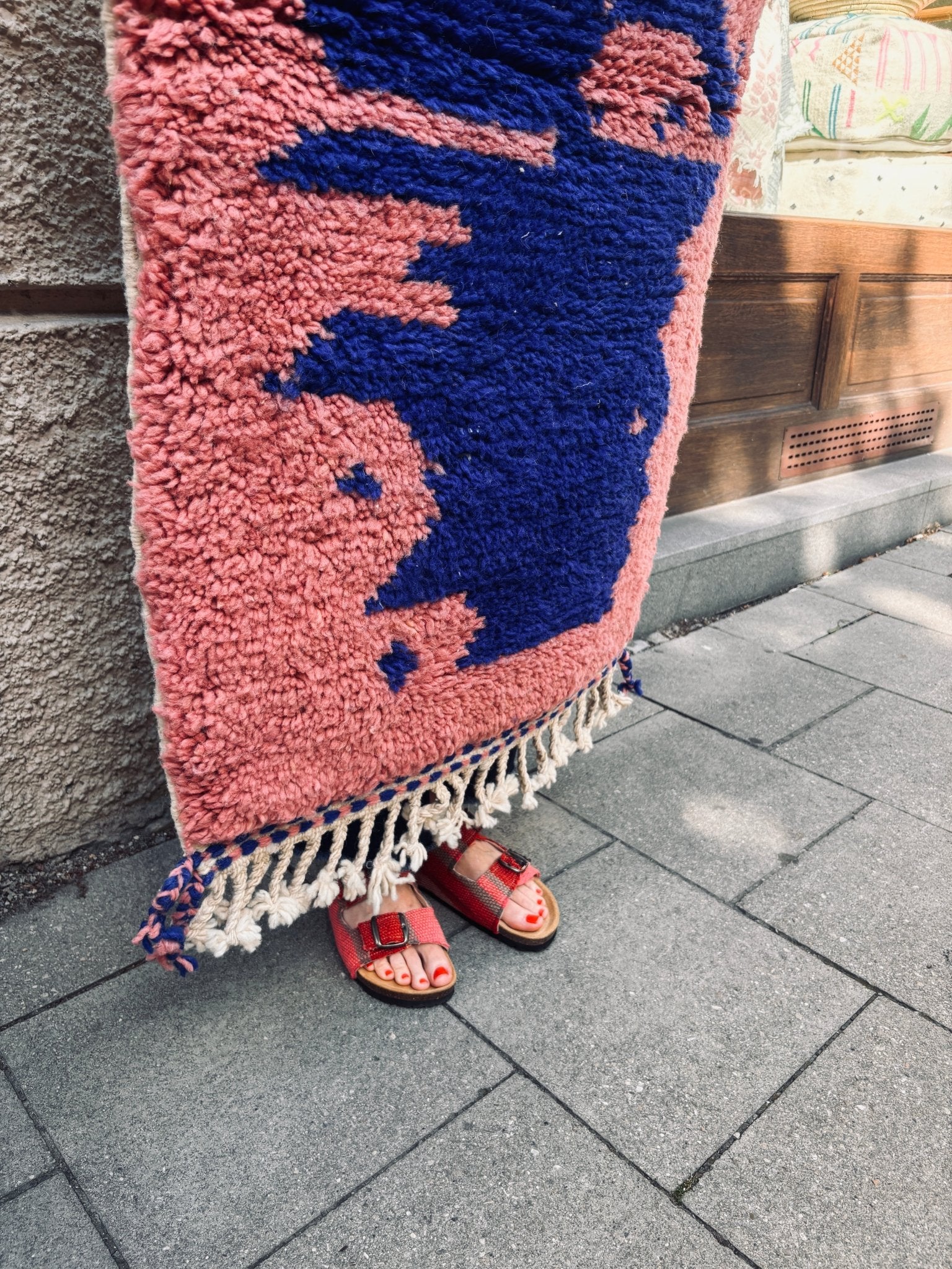Eine Person steht auf dem Berber-Teppich „THE DANISH GIRL INTERIOR – Farah“ (0,60 x 1,10 m); ihre Füße in roten Sandalen sind zu sehen.