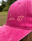 Nahaufnahme der grünen LEY! „Love it“-Kappe mit der Aufschrift „Love it!!“ in Schreibschrift auf der Vorderseite.
