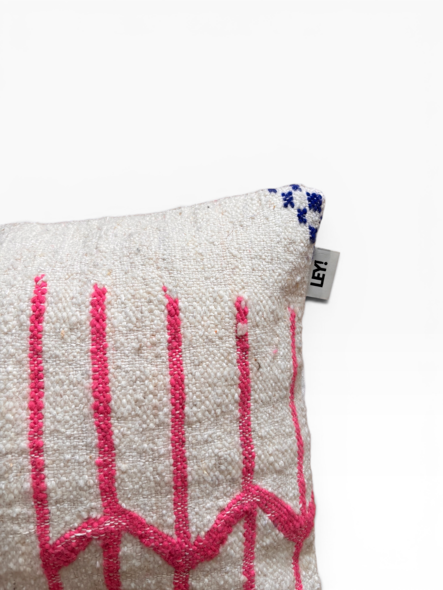LEY! Kissen – Colorful Line, 40 x 60 cm: Beiges Kissen mit rosa Zickzackmustern, blauem Muster und Seitenetikett von LEY!.