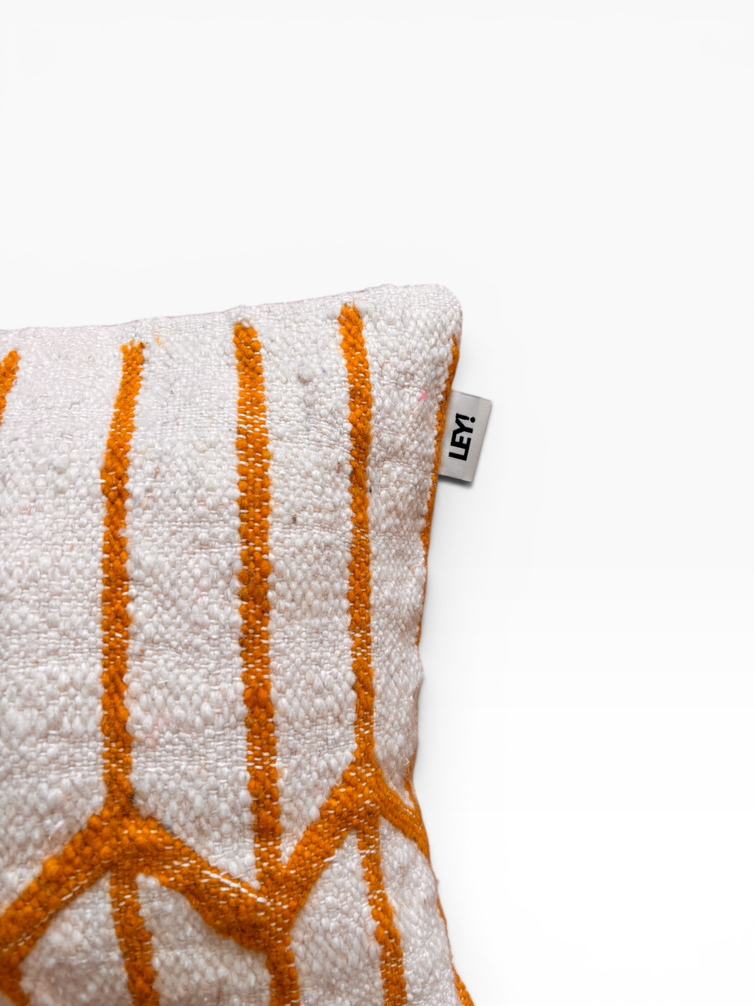 LEY! Kissen – Colorful Line 40x60: Ein weißes Kissen mit orangefarbenen geometrischen Mustern, inspiriert von der Handwerkskunst aus Marrakesch.