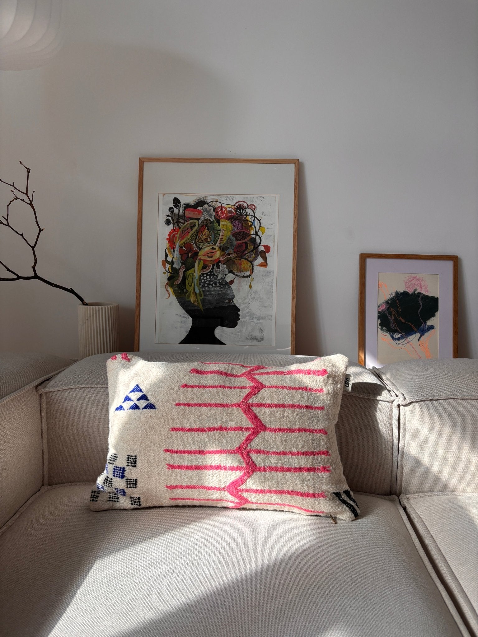 Ein Sofa mit einem LEY!-Kissen – „Colorful Line“ – 40 x 60 von LEY! sowie handgefertigte Kunst aus Marrakesch, die im Sonnenlicht strahlt.