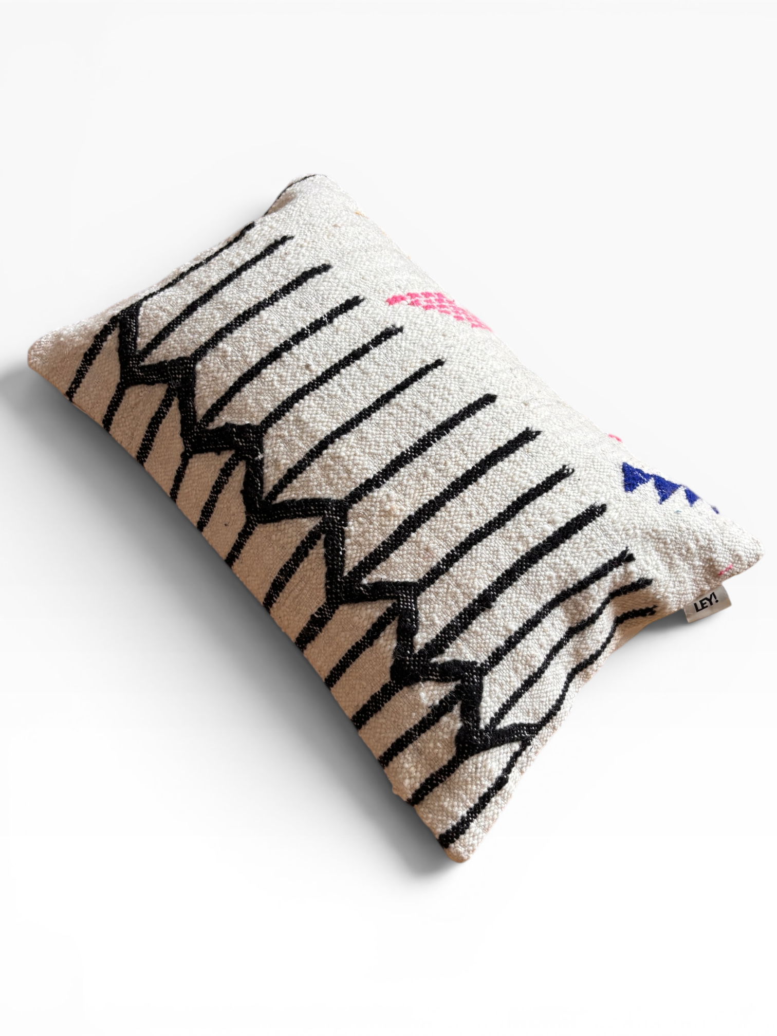 LEY! Kissen – Colorful Line, 40 x 60 cm: Schurwolle, schwarze Zickzackstreifen, bunte Formen auf hellem Hintergrund.