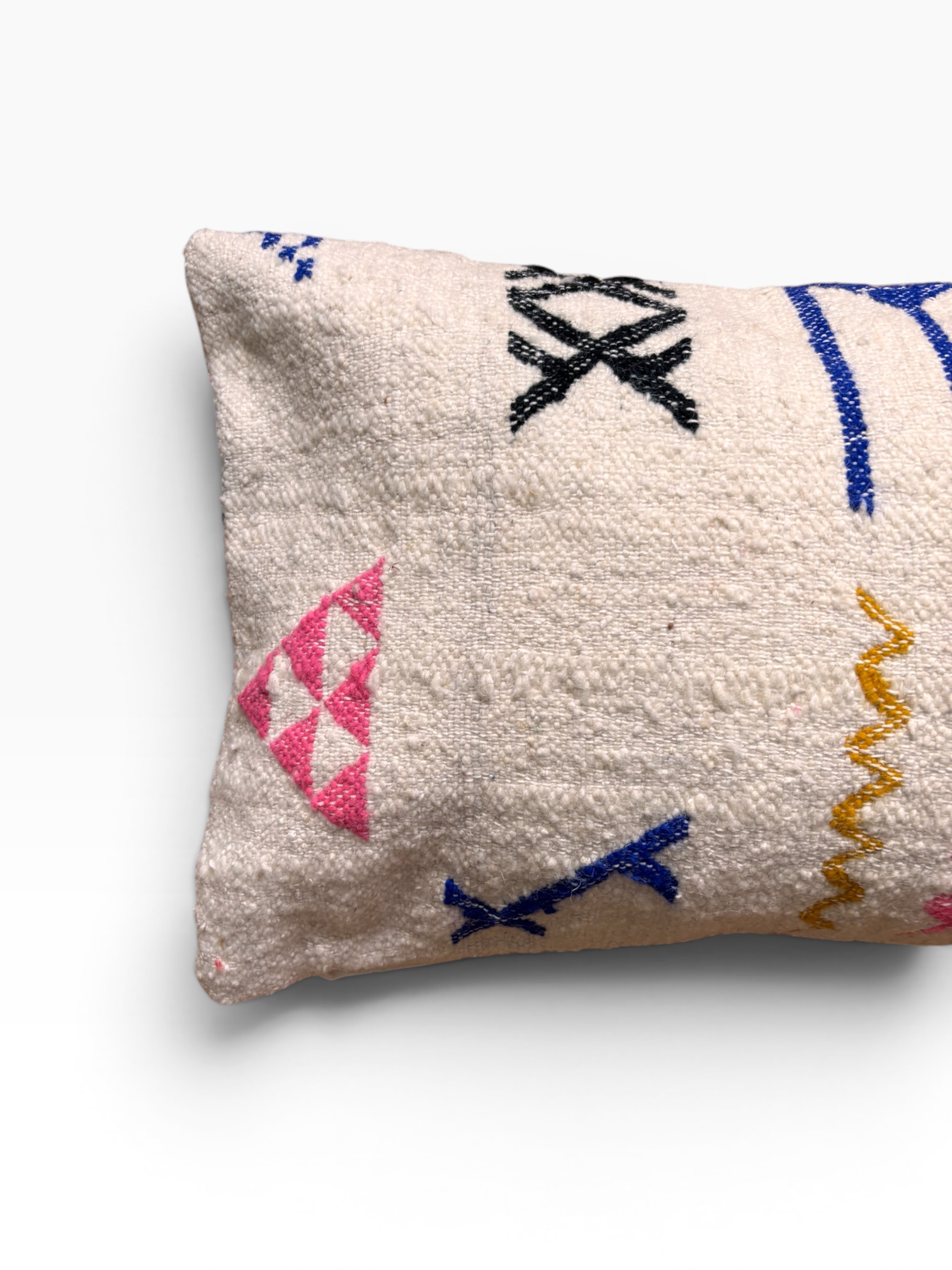 LEY! Kissen – Colorful Line: Ein weißes Kissen aus Wolle im Format 40 x 60 mit geometrischen Ziernähten in Rosa, Blau, Schwarz und Gelb.