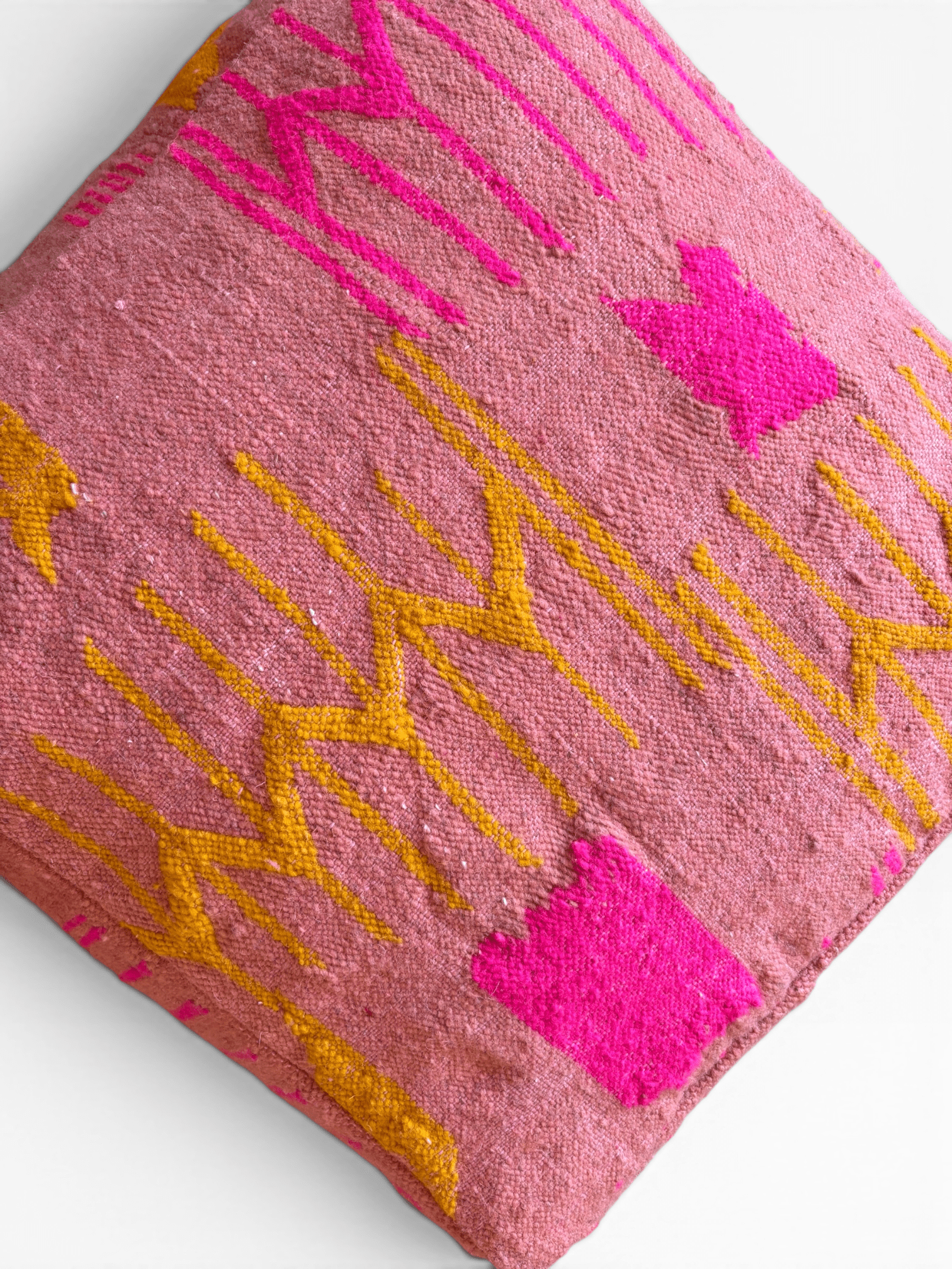 LEY! Bodenkissen – Colorful Line Terra III: Quadratisches Kissen in Terrakotta mit rosa-gelben geometrischen Mustern auf strukturiertem Stoff.