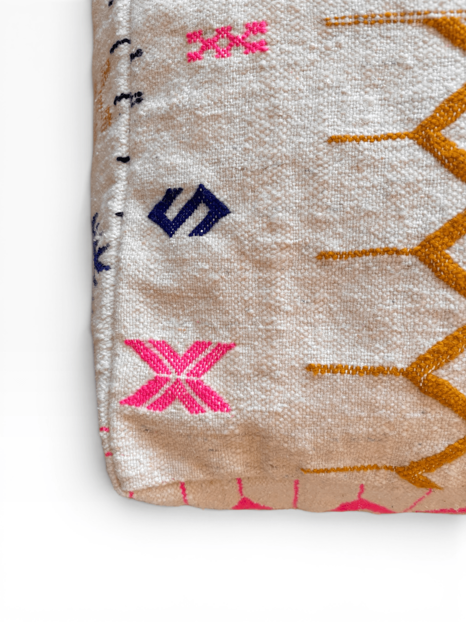 Folded LEY! Bodenkissen – Colorful Line – Kantia mit rosa, gelben und blauen geometrischen Stickereien auf beigem Grund.