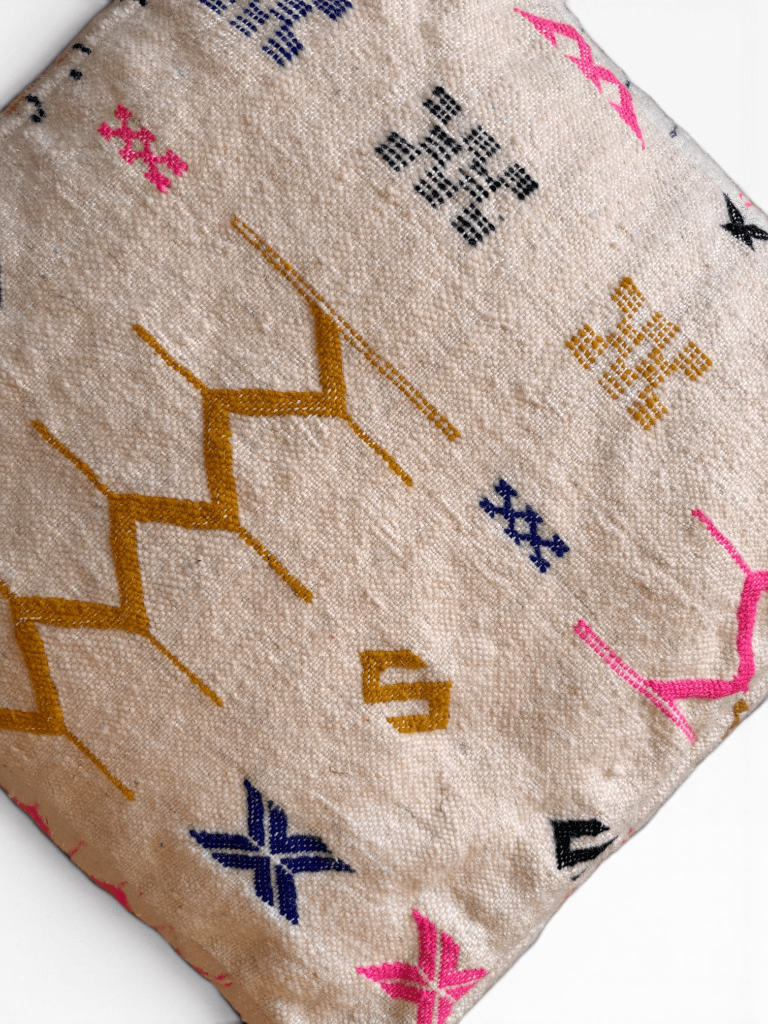 Das LEY! Bodenkissen – Colorful Line – Kantia: ein beiges Kissen mit lebhafter geometrischer Zickzack-Stickerei.