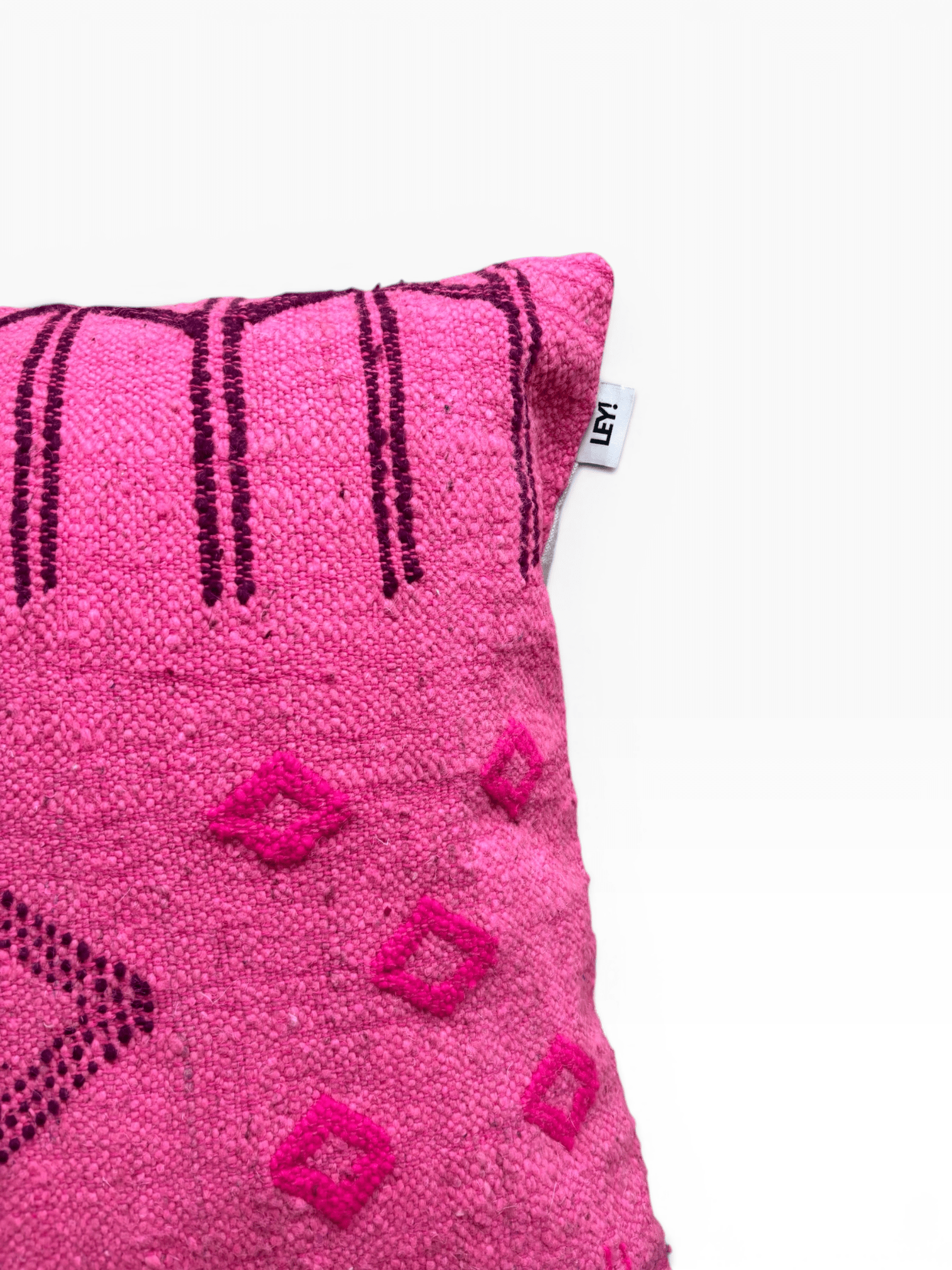 Ein LEY!-Kissen – Colorful Line – Pink Edition – Ein 50 x 50 Kissen mit dunklen Mustern vor einem schlichten weißen Hintergrund.