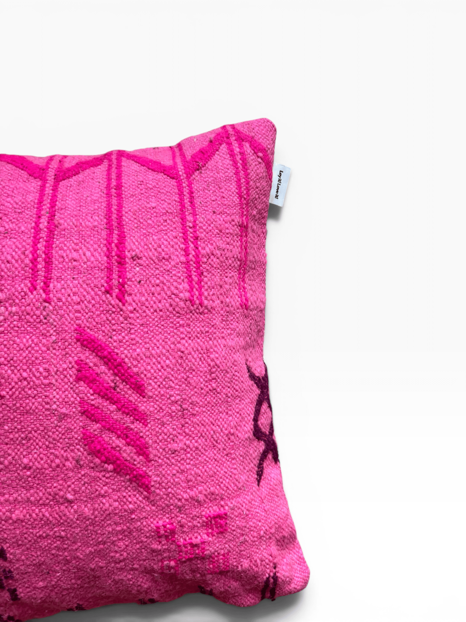 Ein LEY!-Kissen – Colorful Line – Pink Edition 50x50, links teilweise vor weißem Hintergrund zu sehen.