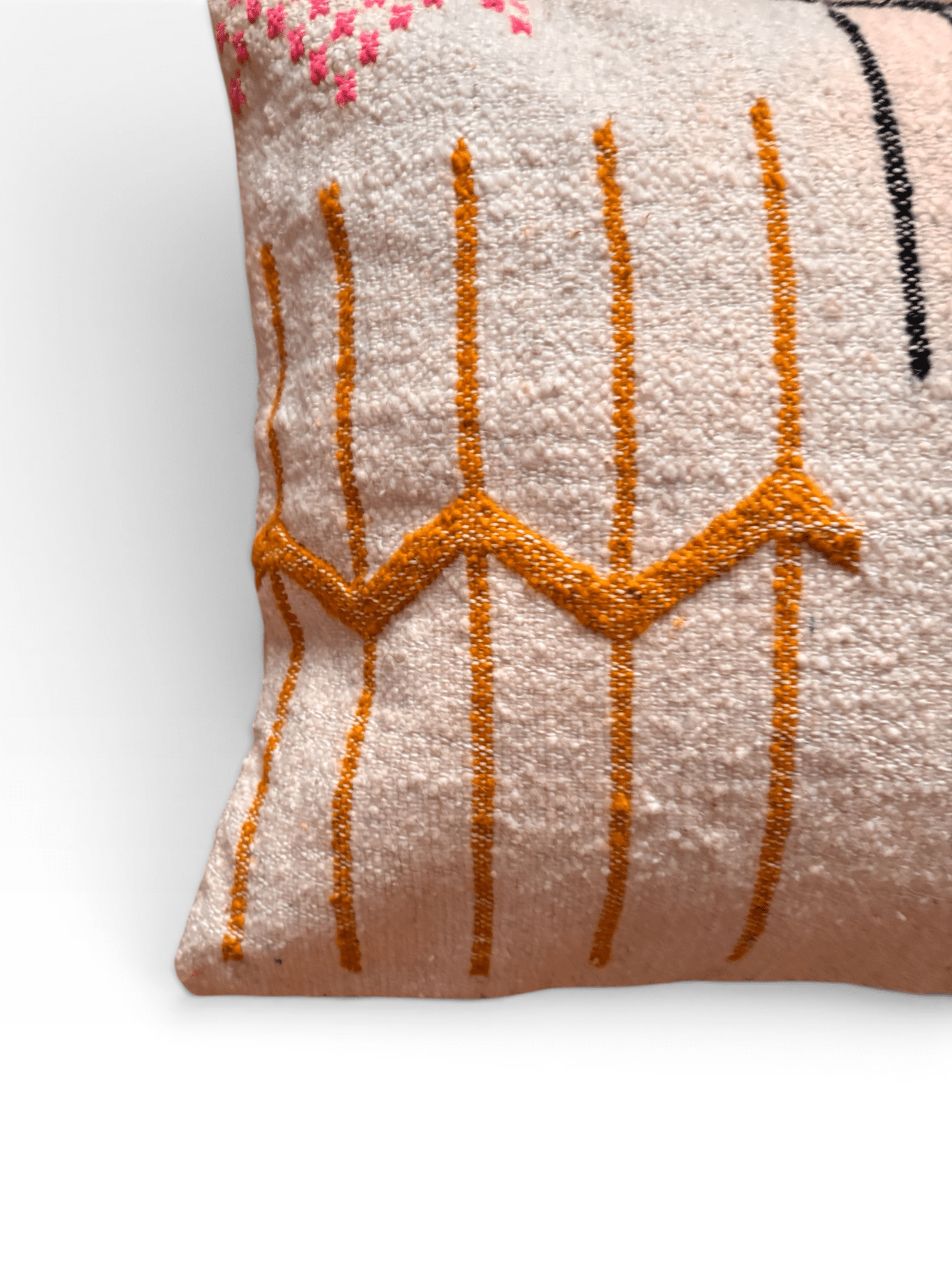Eckstück eines LEY!-Kissens – Colorful Line 50 x 50, beige Wolle, mit gelbem Zickzackmuster und rosa-schwarzen Ziernähten.