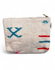 Die LEY! Tasche - Colorful Line - 20x30cm ist eine kleine, strukturierte cremefarbene Schurwolle-Tasche mit einem Reißverschluss an der Oberseite und leuchtend blauen, roten und rosa gestickten geometrischen Mustern - ein einzigartiges handgemachtes Marrakesch-Accessoire für jeden Stil.