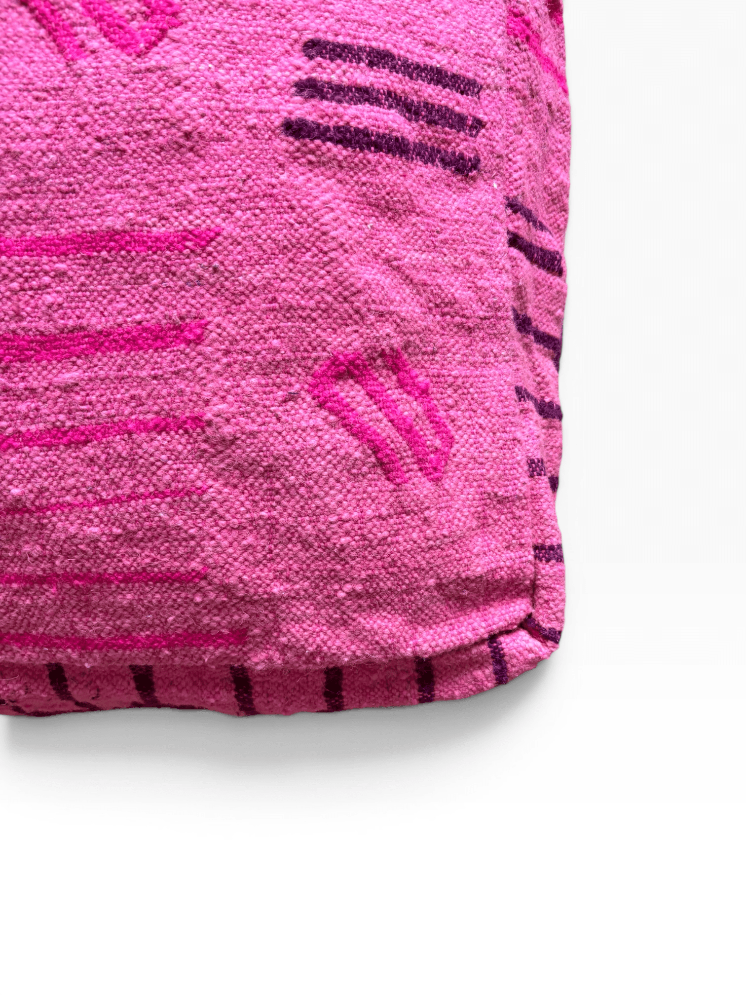 Eine Nahaufnahme des „Bodenkissen – Colorful Line – Pink Edition“ von LEY! mit rosa geometrischen Wollmustern.