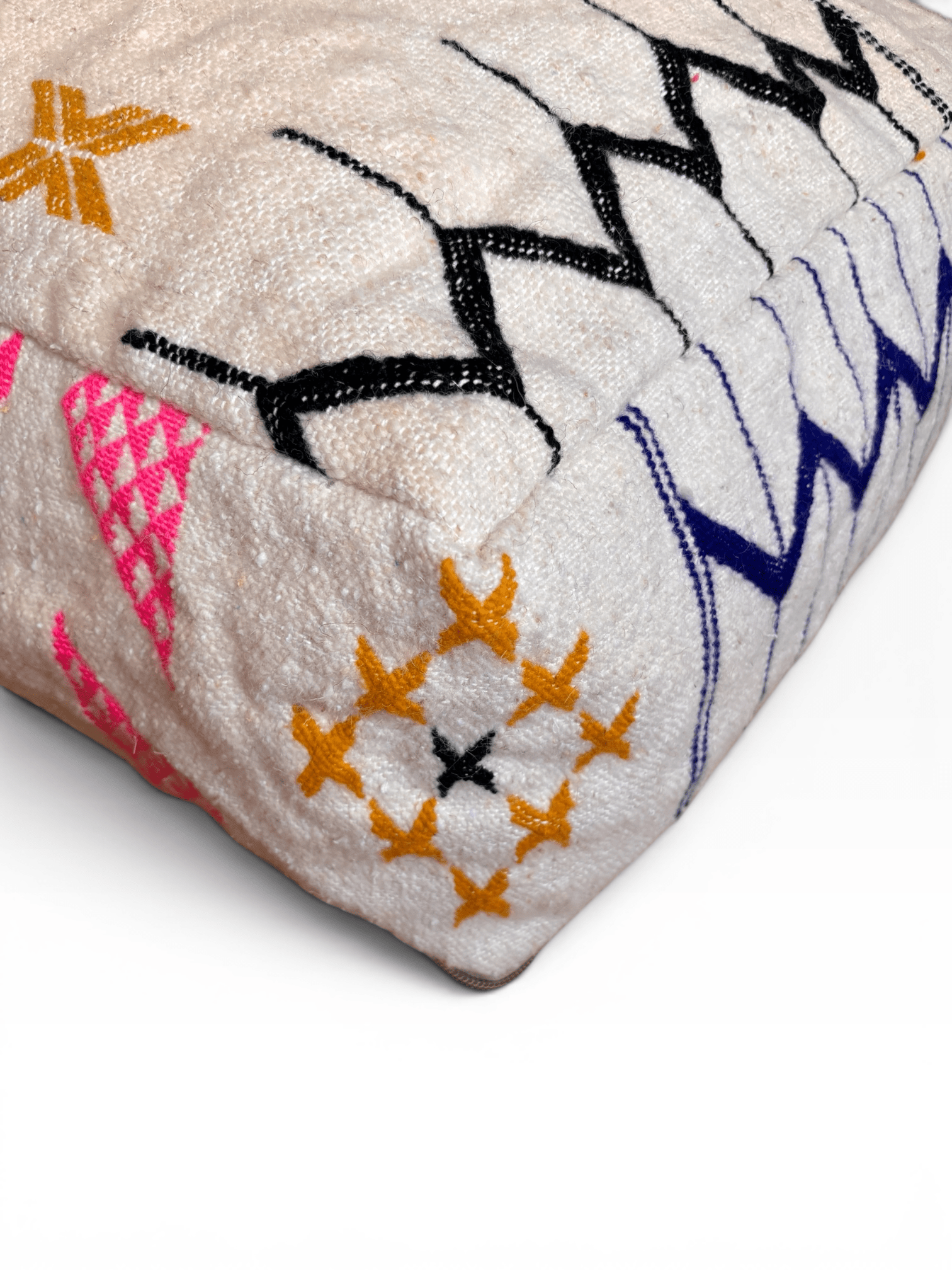 Ein weißes LEY! Bodenkissen – Colorful Line – Lavina mit schwarzen, gelben, rosa und blauen geometrischen Stickereien.